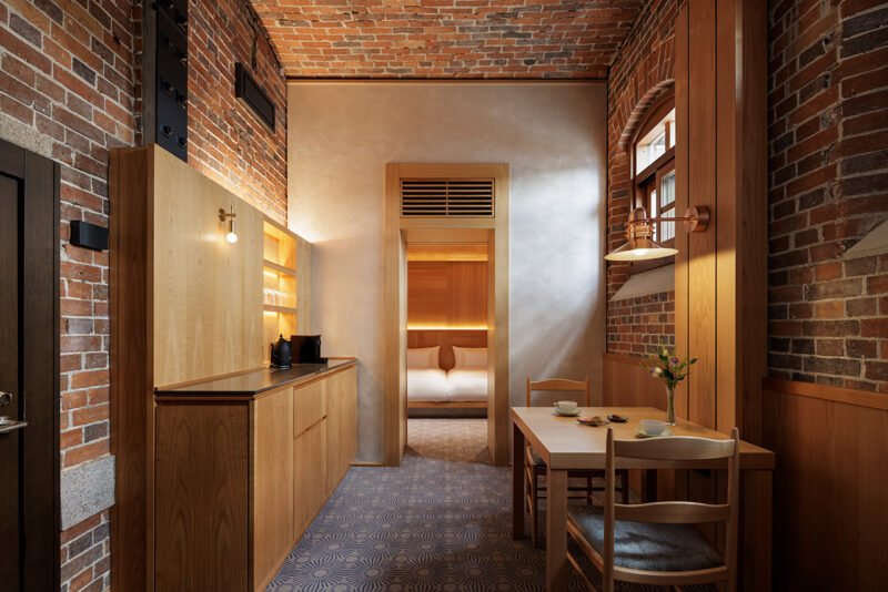 Suite living space with exposed brick walls, timber fittings and a sequence of openings