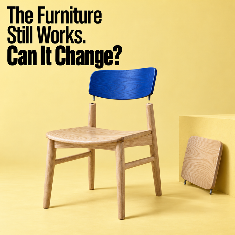 Wooden chair with a detached blue backrest above its frame and a spare wooden backrest beside it, illustrating upgradable furniture design.
