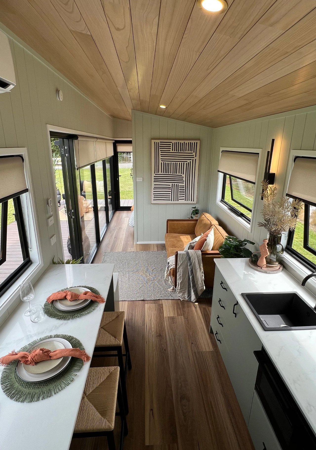 Kitchen, narrow dining counter and sitting area beneath the timber ceiling