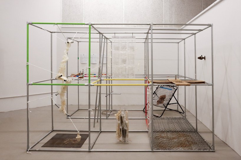 Modular metal frame with suspended objects, coloured rails and transparent pockets