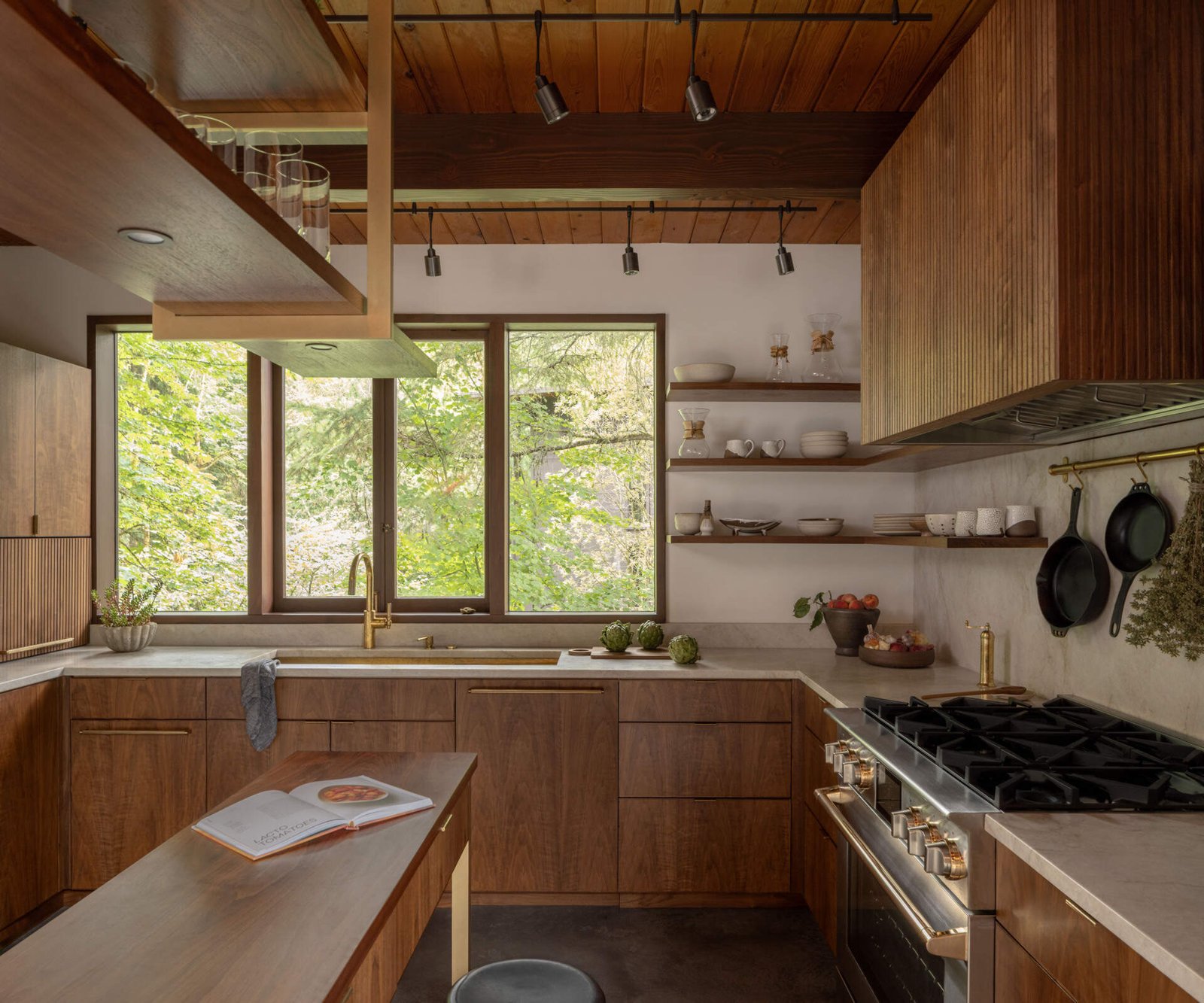 The kitchen connects its island, window and working surfaces