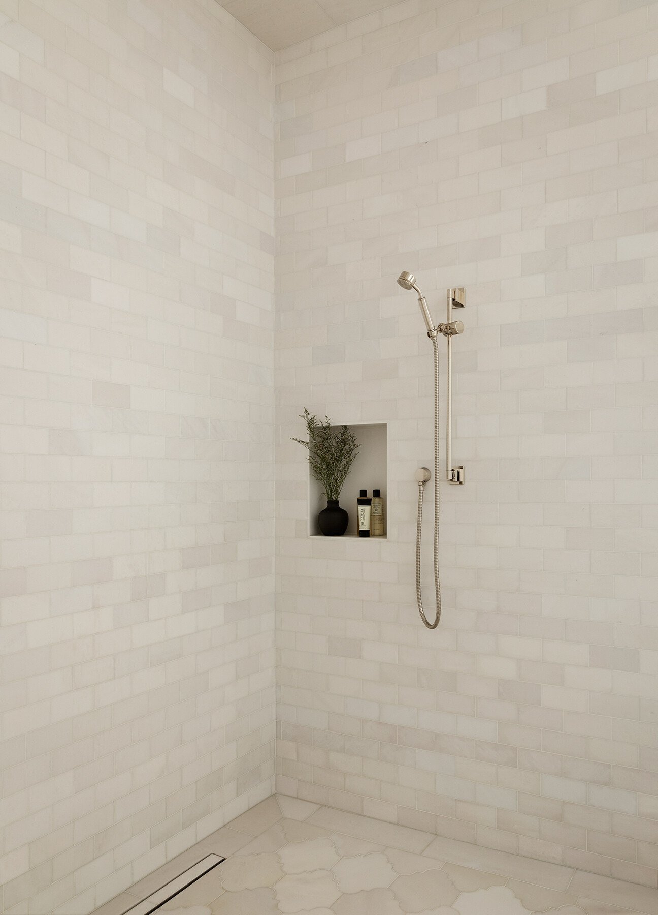 A glass shower enclosure retains visual continuity across the bathroom.