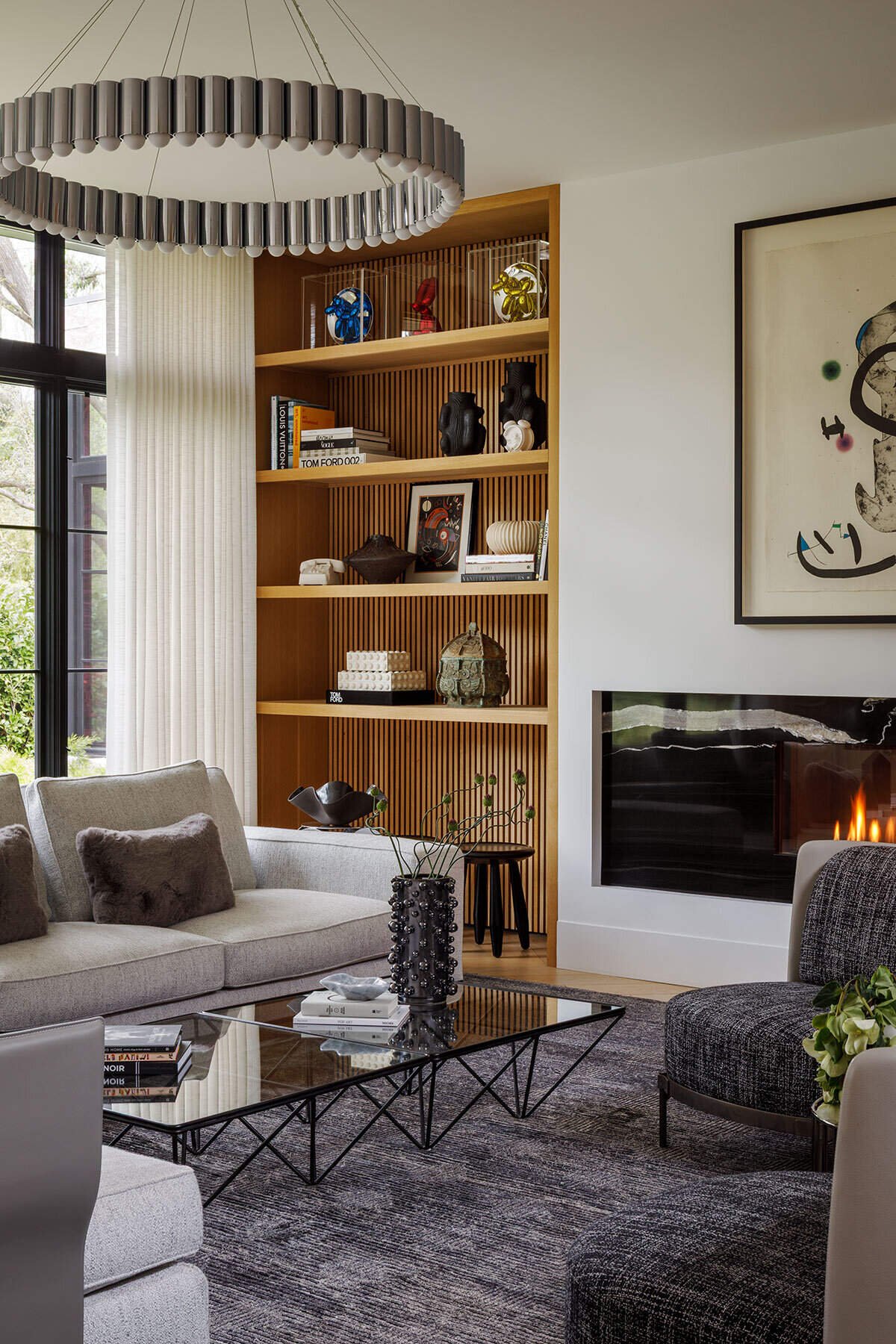 Art above the fireplace shares the wall with the room&rsquo;s domestic focal point.
