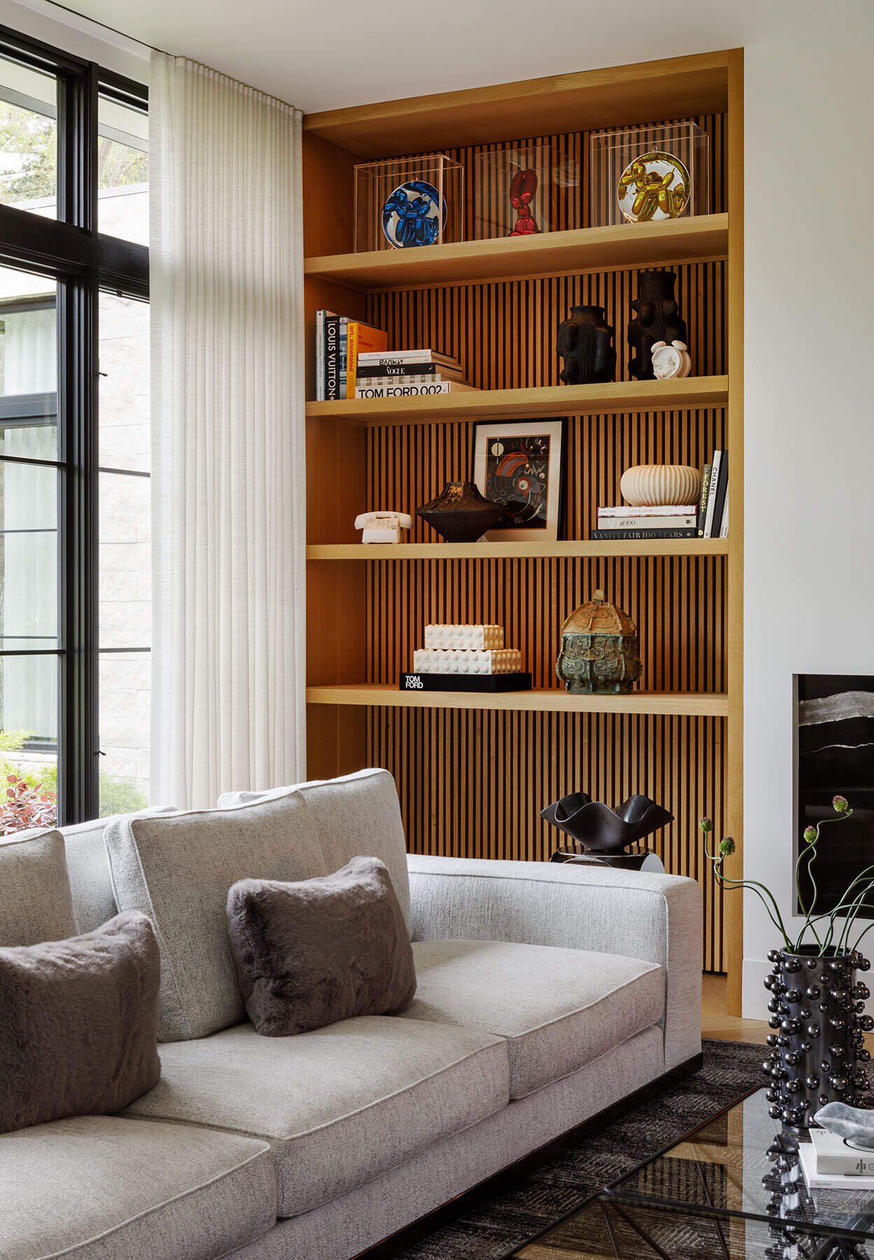 Bleached-oak shelving holds books, ceramics and sculptural objects.