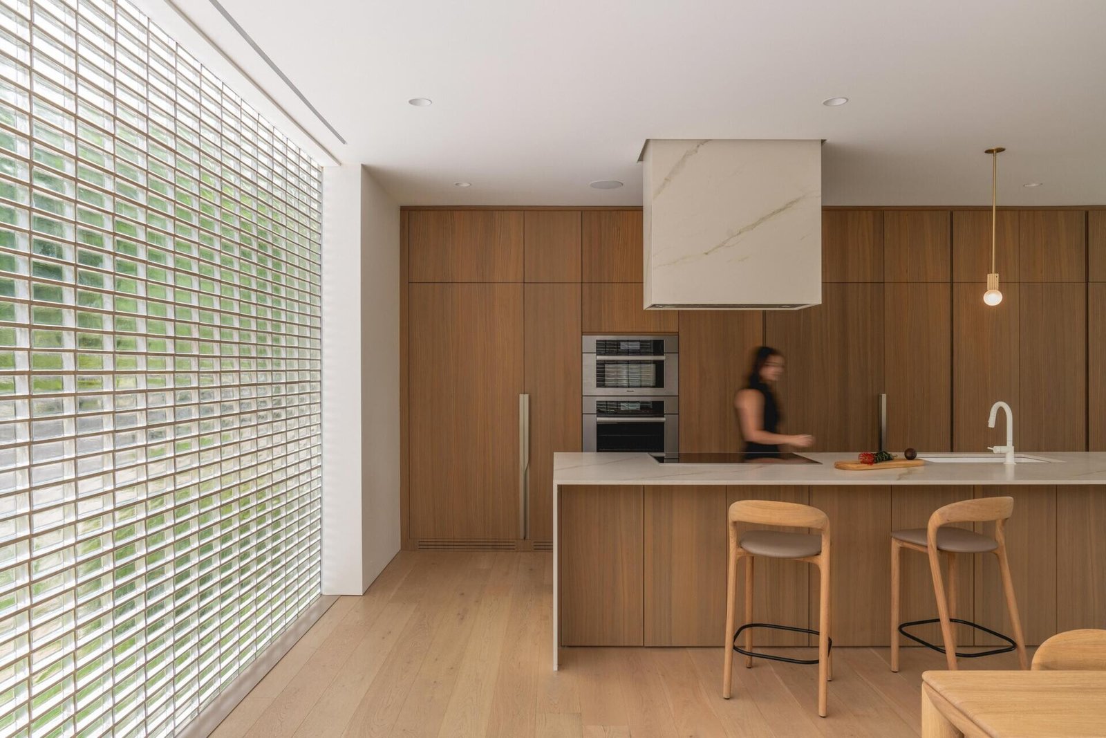 Walnut storage forms the backdrop to the porcelain-topped kitchen island.