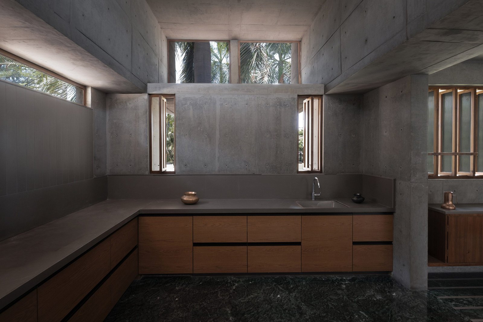 Monastic Field kitchen with dark stone worktops, timber cabinetry and high windows