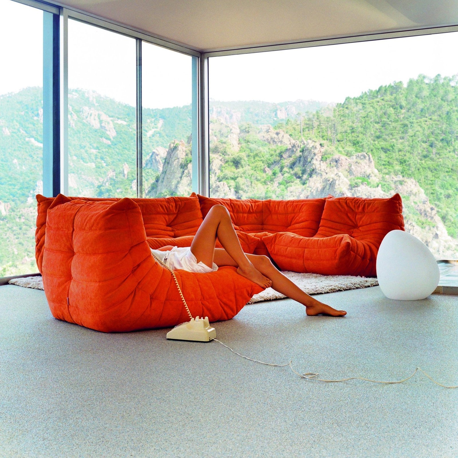 Red Togo seating beside full-height glazing